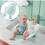 Soporte para bañera de bebé, blanco y turquesa, con bebé sentado en lavabo.