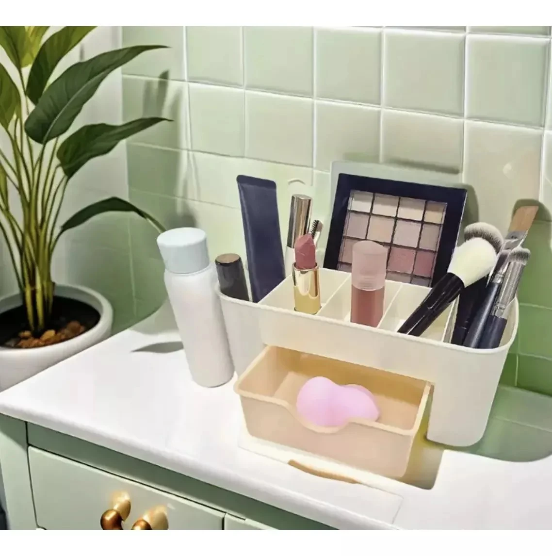 Organizador de maquillaje blanco con compartimentos para cosméticos, labial, brochas y paleta de sombras, sobre un tocador.