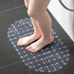 Tapete de baño transparente con ventosas para evitar caídas. Pies sobre tapete antideslizante.