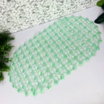 Tapete de baño de succión transparente con puntos verdes.
