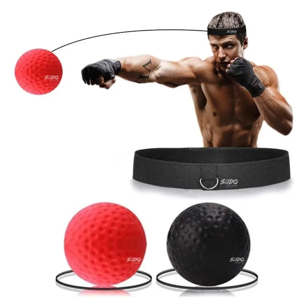 Boxeador entrena con pelota de boxeo roja para cabeza sujeta a cinta negra. Balón negro a un lado.