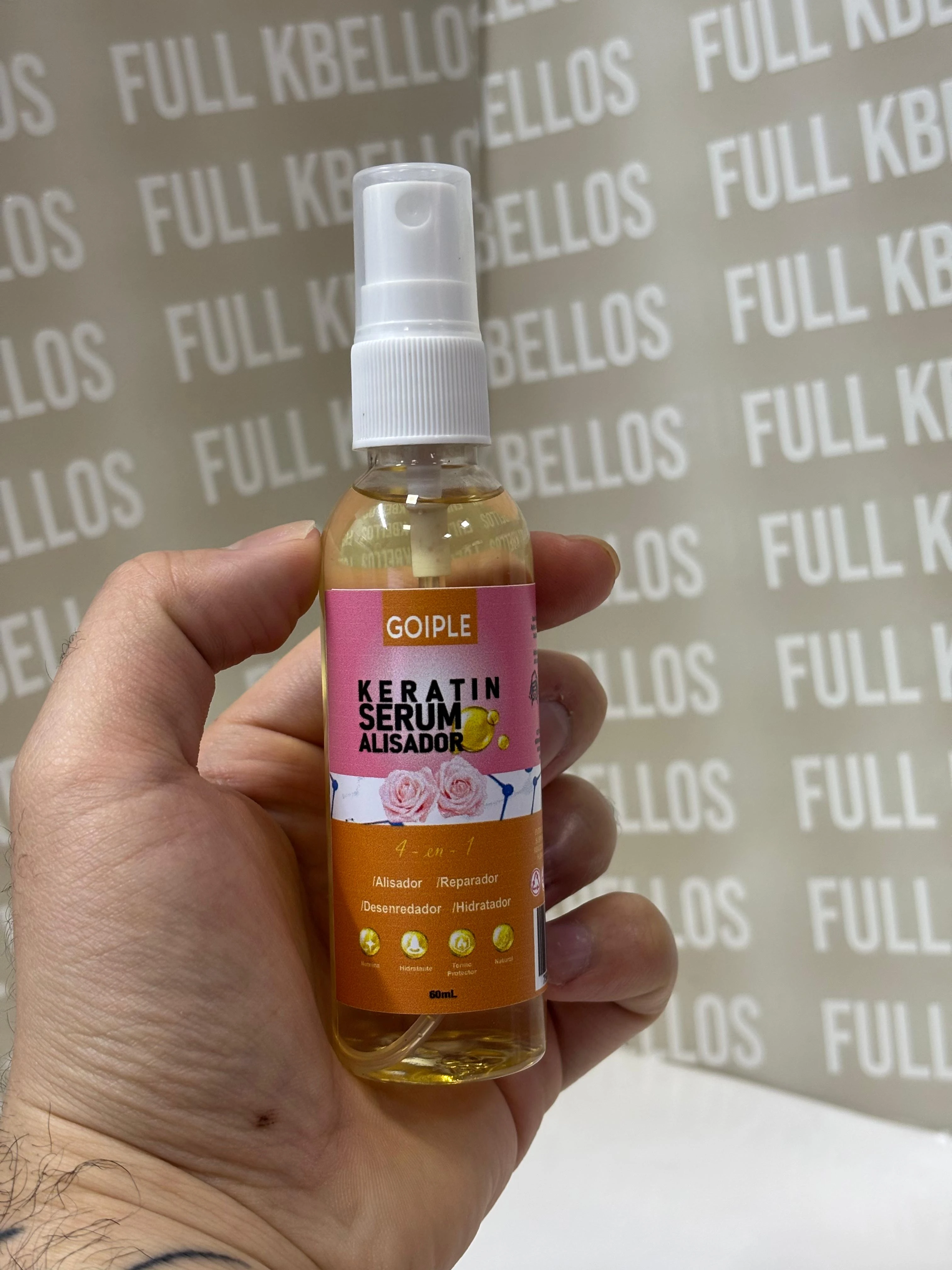 Serum Keratina Alisador 60ml GOIPLE en mano, con gotas doradas y rosas, para controlar frizz y facilitar peinado.