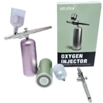 Aerógrafo inalámbrico portátil plateado con depósito violeta y verde, y envase.