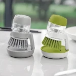 Cepillos dispensadores de jabón para lavaplatos, uno gris y otro verde, con base y tapa.