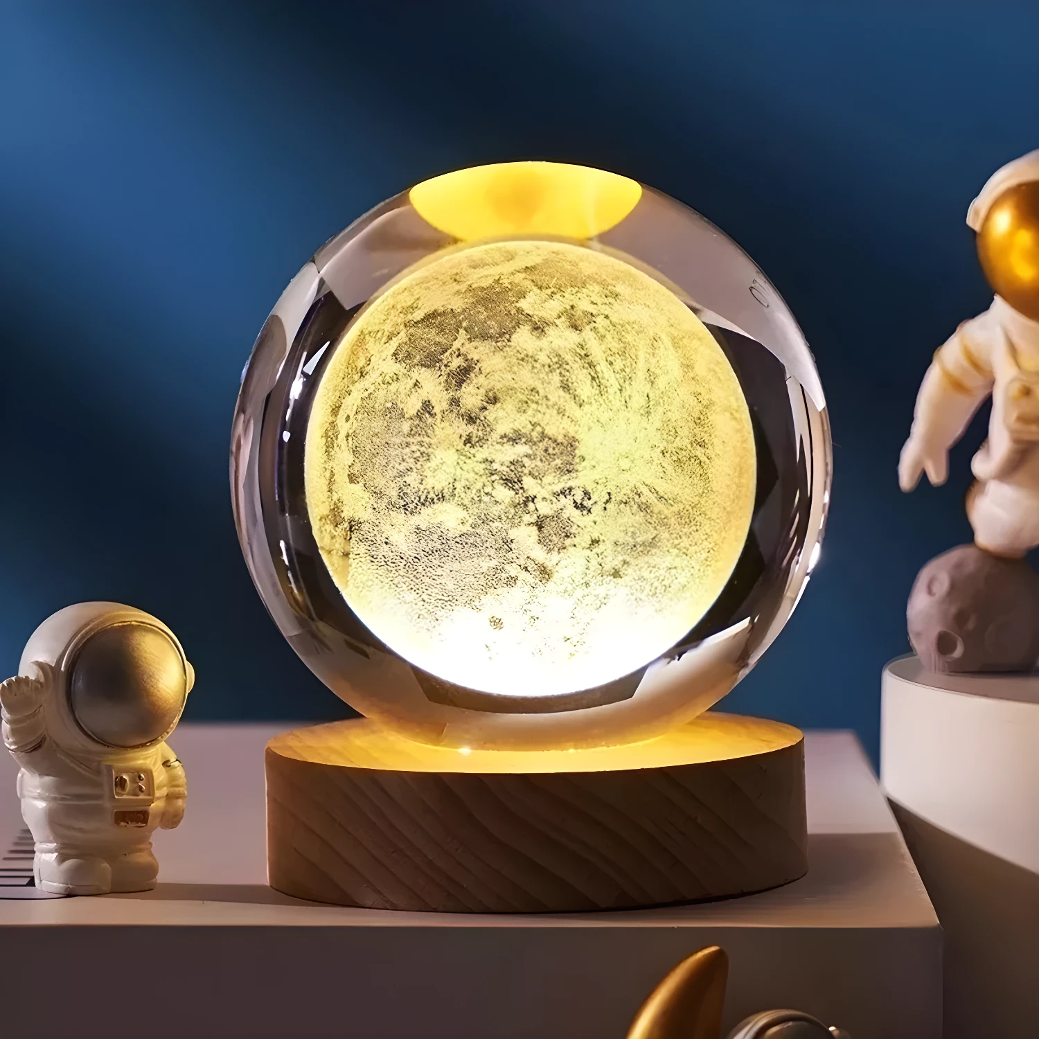 Lámpara de escritorio 3D con esfera de luna en cristal y base de madera, acompaña un astronauta.