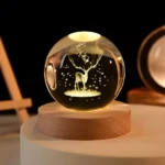 Esfera de cristal 3D con ciervo iluminado y base de madera.