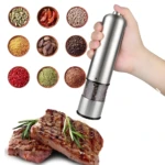 Molino de pimiento eléctrico plateado moliendo granos sobre un filete de res.
