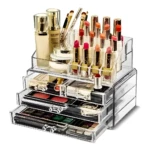 Organizador de acrílico transparente con labiales, bases, brochas y paletas de sombras.