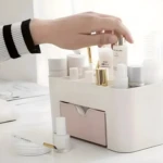 Organizador de maquillaje blanco con cajón rosa, ideal para cosméticos.