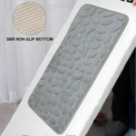 Tapete de baño gris texturizado imitando piedras, con base antideslizante SBR.