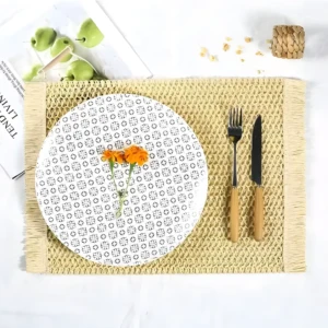 Mantel individual tejido color amarillo con diseño geométrico y flecos. Incluye plato, cubiertos y flores.