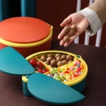Organizador de 4 compartimentos, amarillo y verde, con tapas y varios dulces, tomates y frutos secos.