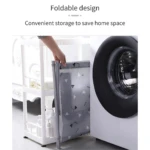 Canasta de ropa plegable gris con triángulos, guardándose entre un estante blanco y lavadora.