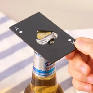 Destapador negro metálico en forma de as de picas, abriendo una botella de cerveza.