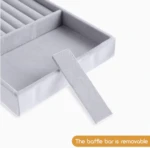 Organizador de joyas gris de terciopelo con divisor extraíble para anillos.