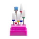 Set de siete puntas de cerámica para drill de uñas, incluyendo fresas cilíndricas y cónicas de colores, sobre una base organizadora de color rosa.