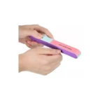 Manos sosteniendo una lima bloque de manicura de siete lados con superficies texturizadas en colores morado, verde claro y rosa con texto impreso.