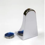 Soporte pared jabonera magnética cromada con base curvada y dos tapas de metal con adhesivo azul.