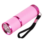 Mini linterna LED UV rosa con correa negra, cuerpo texturizado y detalles metálicos brillantes.