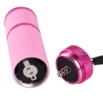 Mini linterna LED UV rosada, con detalle de resortes para batería, lista para usarse.