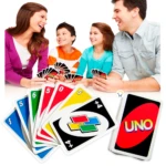 Familia sonriente jugando al juego de cartas UNO clásico, con cartas visibles en primer plano.