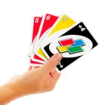 Mano sosteniendo cartas de Uno clásico: cinco, cero, cinco rojo y amarillo, y dos cartas comodín "+4" negras.