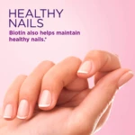 Primer plano de una mano femenina con manicura natural, destacando uñas cuidadas sobre fondo rosado, junto al texto sobre los beneficios de la biotina.