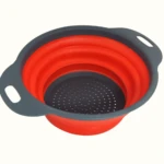 Colador redondo plegable de silicona naranja con base y borde gris.