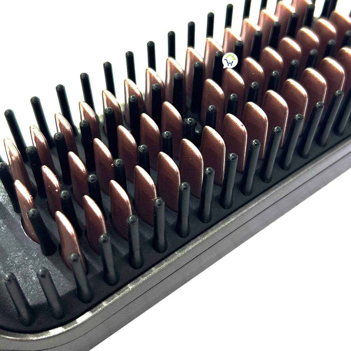 Primer plano de cepillo alisador con placas de cerámica en tono cobrizo y dientes protectores negros distribuidos uniformemente para peinar y alisar.