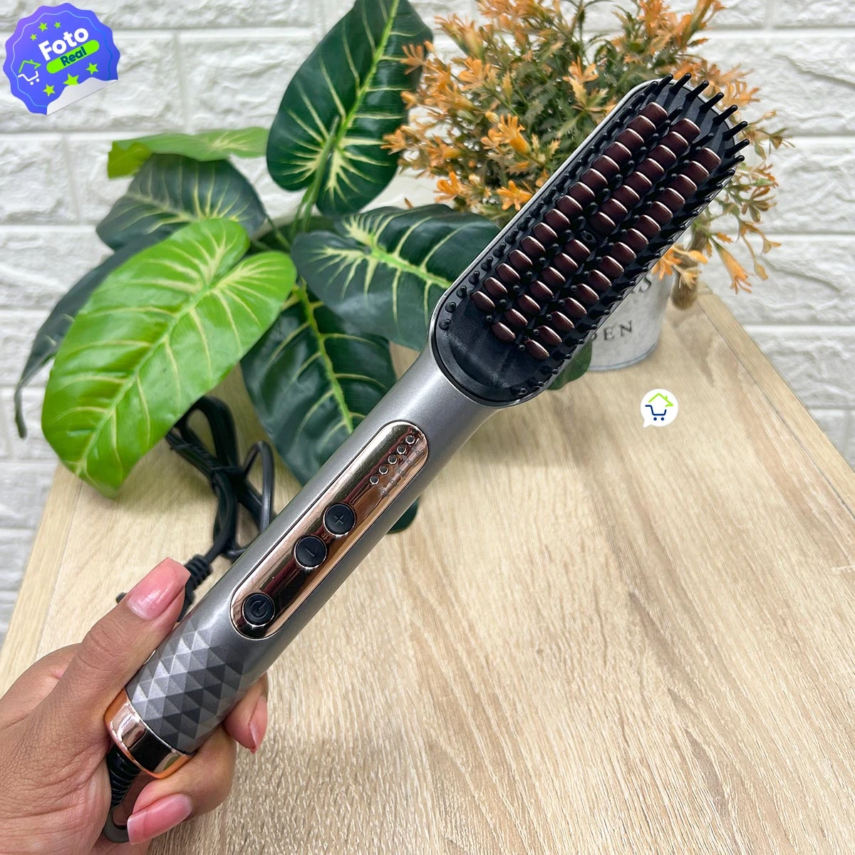 Cepillo alisador Pro950 color gris metálico con dientes de cerámica, mango antideslizante, control de temperatura y cable, sostenido por una mano.