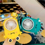 Llavero mini ventilador portátil amarillo con forma de criatura, junto a uno verde con diseño similar.