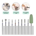 Set de 10 brocas para torno de uñas con texturas diamantadas y una pulidora de silicona verde, organizadas en una base transparente para manicura precisa.
