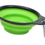 Tazón plegable para mascota, silicona verde lima con borde negro, incluye mosquetón metálico para transporte.