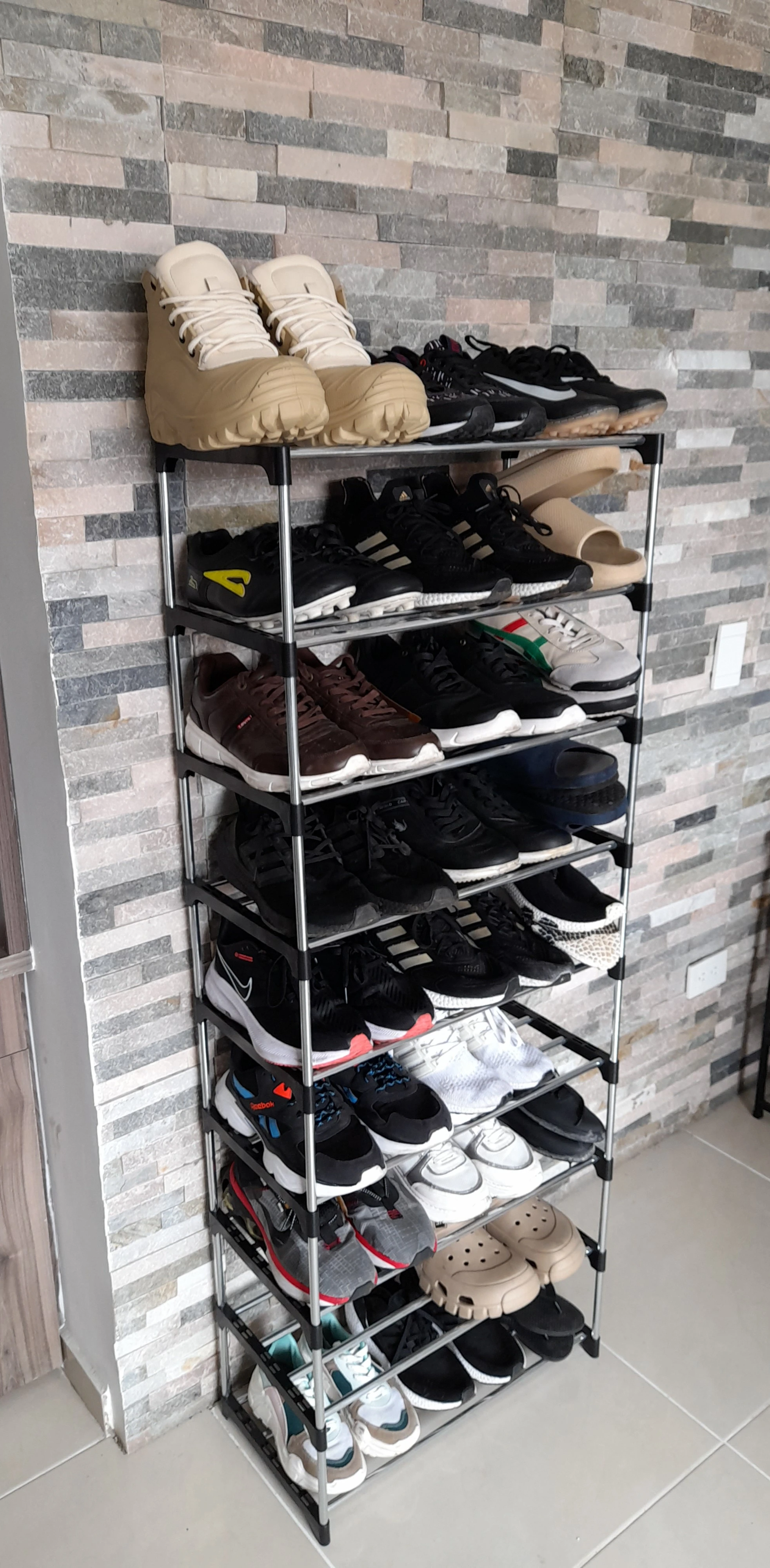 Organizador de zapatos de 9 niveles en color negro con diversos tipos de calzado deportivo y casual en tonos oscuros y claros.