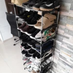 Organizador de zapatos 27 pares 9 niveles con múltiples zapatillas y botas de diversos colores y estilos.