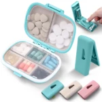 Pastillero organizador de medicamentos azul con cortador y pastillas, tres divisores.