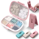 Pastillero rosa con 6 compartimentos y cortador de pastillas, incluye estuches pequeños.