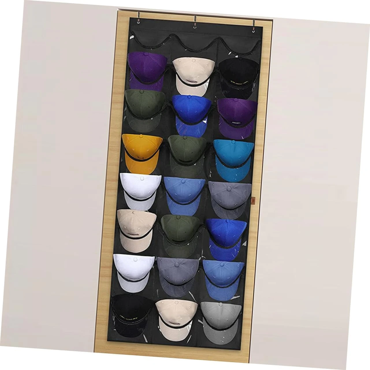 Organizador colgante negro de 30 bolsillos transparentes, lleno de gorras de béisbol de varios colores.