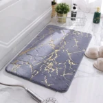 Tapete de baño afelpado gris con diseño marmoleado dorado, ideal para absorción y seguridad.