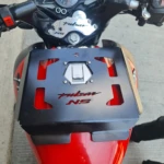 Parrilla negra para tanque de motocicleta Bajaj Pulsar NS, con logo rojo y detalle hexagonal.