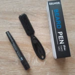 Lápiz negro para barba y cejas Eelhoe junto a cepillo aplicador sobre superficie de madera clara.