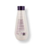 Botella blanca de tratamiento capilar con tapa morada, detalle de ingredientes y fecha de vencimiento en etiqueta.