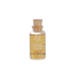 Frasco de vidrio con tónico capilar vigorizante dorado, con corcho y etiqueta blanca con logo y texto "Fruto Salvaje".