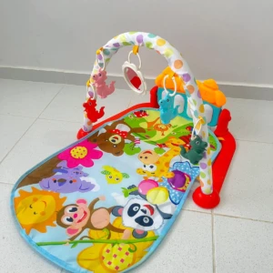 Gimnasio para bebé con piano, tapete didáctico con animales, arco con juguetes colgantes y espejo.