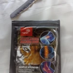 Empaque negro de parches analgésicos Hanel con de tigre, mostrando aplicación en cuello, espalda y rodilla. Contiene 8 unidades.