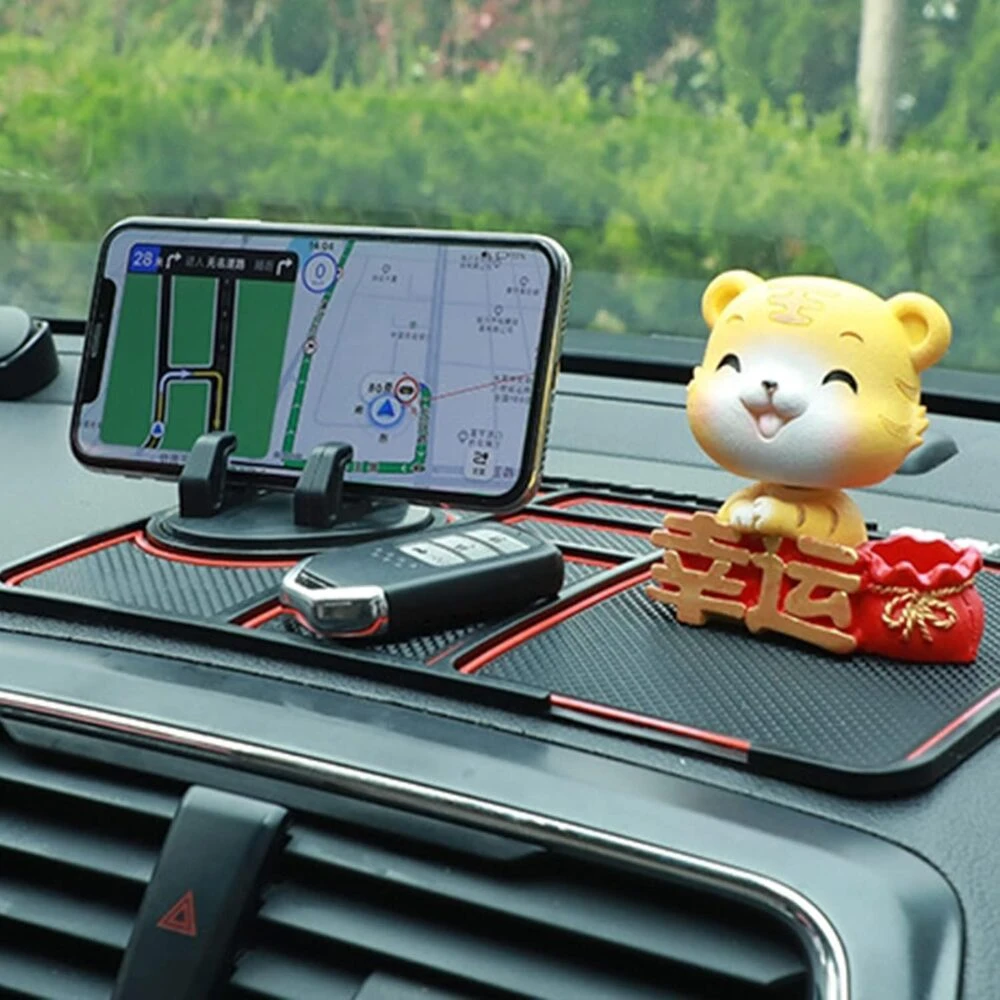 Tapete antideslizante negro para auto con figura de tigre, celular en navegación y llaves.