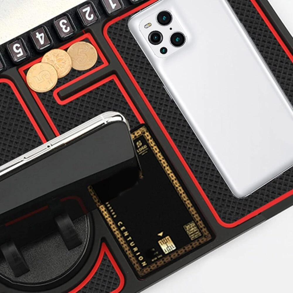 Tapete antideslizante negro con bordes rojos para coche, con ranuras para monedas, celular y tarjeta.