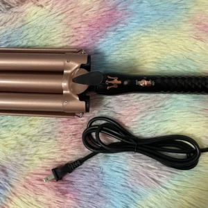 Pinza rizadora de 3 tubos dorada, mango negro texturizado, con cable y enchufe.