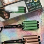Pinzas para el cabello de 3 tubos Remington, una verde y otra color cobre, sobre alfombra colorida.