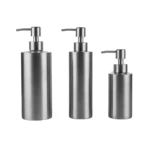 Dispensadores de jabón redondos de acero inoxidable, uno grande y uno mediano en mesa.